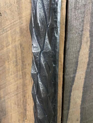 Close up of custom hand-forged wrought iron pineapple twist for door handle