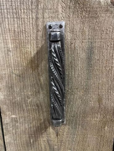 Custom hand-forged wrought iron door handle with complex twist technique