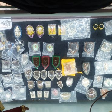 Various amulets and pendants displayed on a black surface.