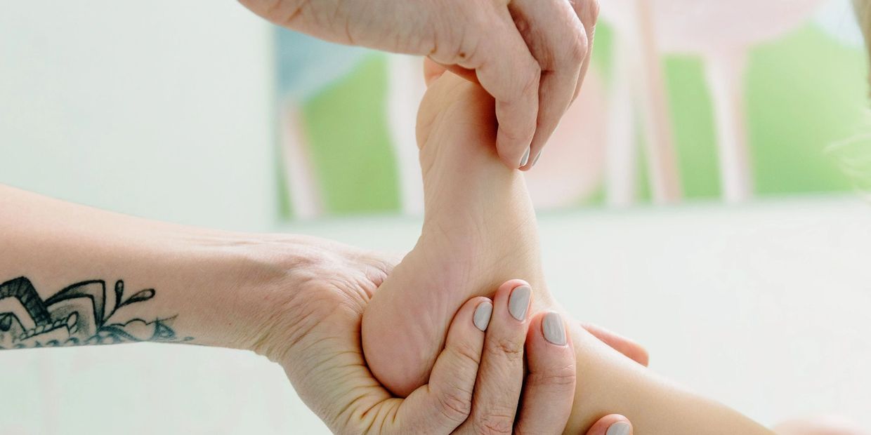 Person massant le pied d'un bébé.