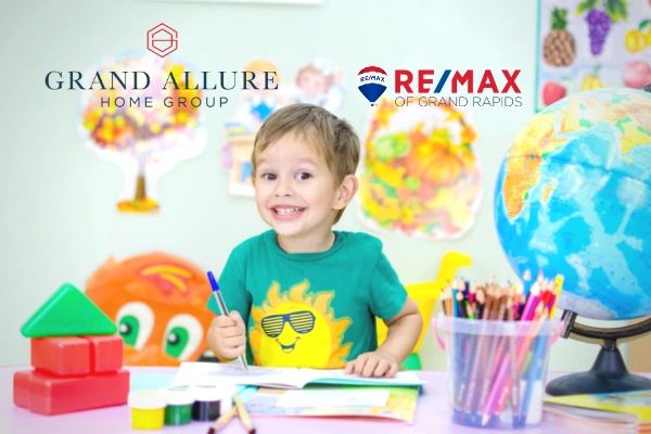 Young child with a marker in his hand drawing while surrounded by artwork and art supplies.
