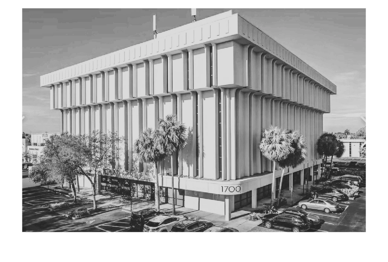 Modern office building with distinct vertical architectural features and adjacent parking lot.