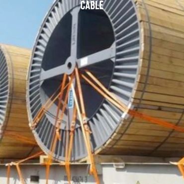 Large wooden cable reels secured with orange straps for transport.