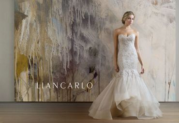 Model in an elegant strapless wedding dress with a flowing skirt.