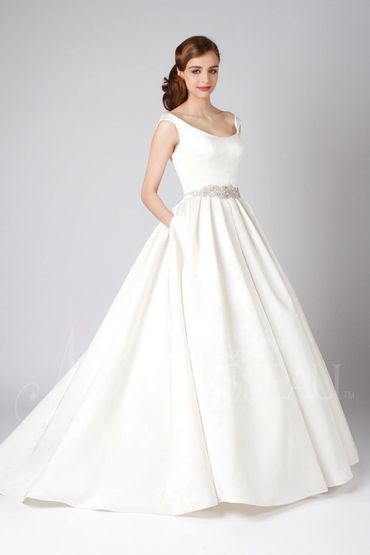 Elegant bride in a classic white wedding gown with a full skirt and embellished waist.