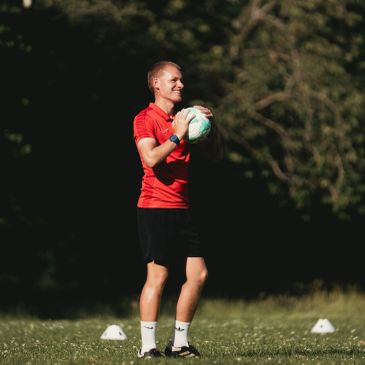 Man holding a soccer ball on a field.