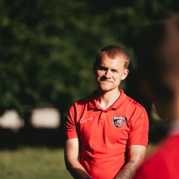 Man in red sports shirt outdoors.