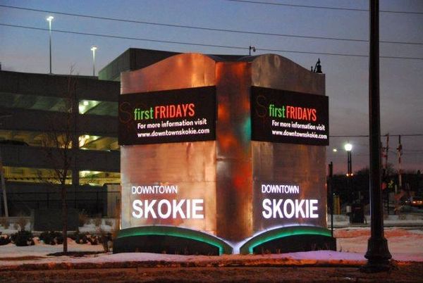 Illuminated sign for Downtown Skokie at dusk.