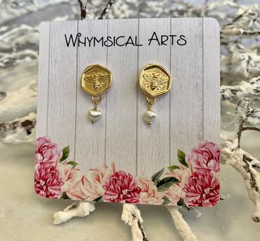Gold bee earrings with pearl drops on floral card.
