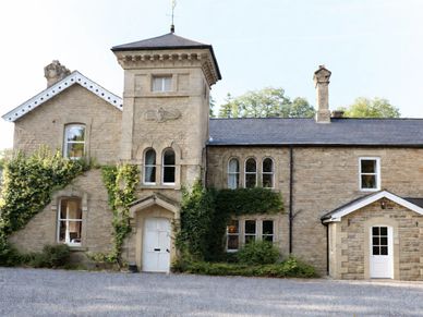 Stone building with ivy climbing its walls and a gravel driveway.