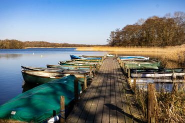 Ormesby Little broad, dinghy rowing boats for hire. reflecting blue sky in the broad. Spring skies