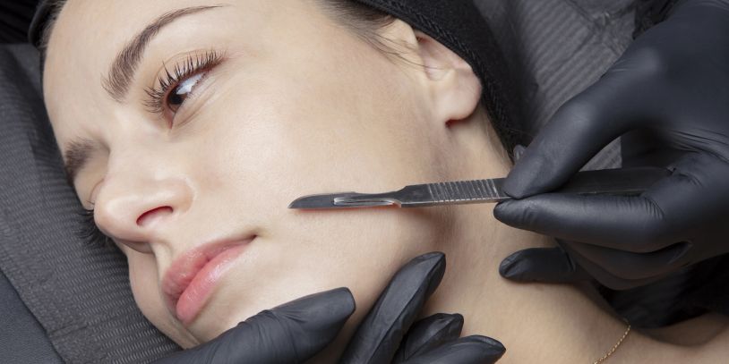 Close-up of a woman undergoing a skincare treatment with a scalpel.