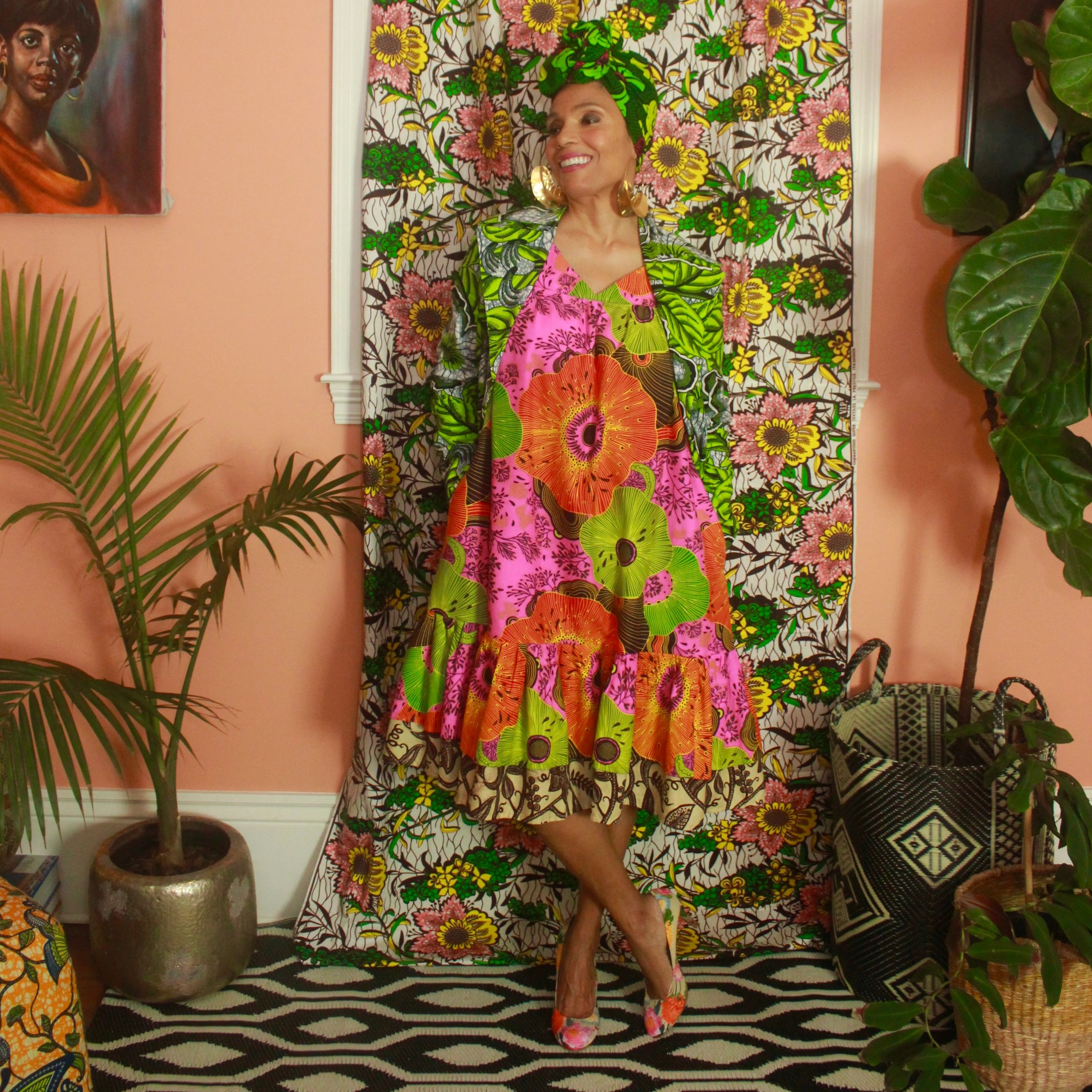 Woman wearing a floral head wrap and dress.