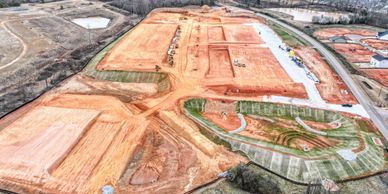 A large construction site with cleared land and foundation work underway.