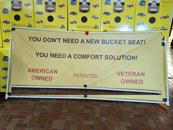 Sign promoting a comfort solution for bucket seats, emphasizing American and veteran ownership.