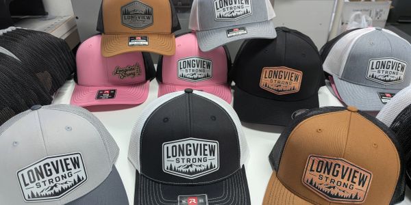 Assorted Longview Strong caps in various colors.