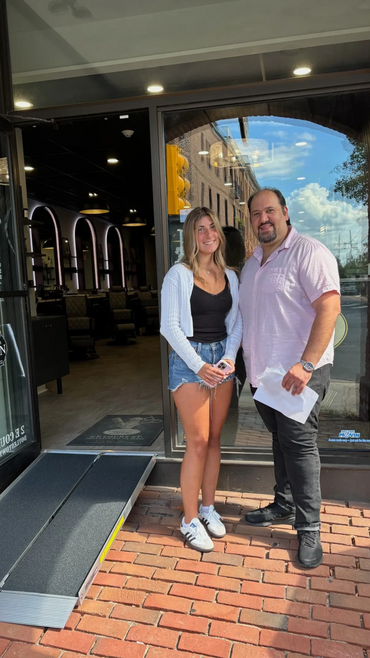 Two women standing looking forward, a woman and a man standing