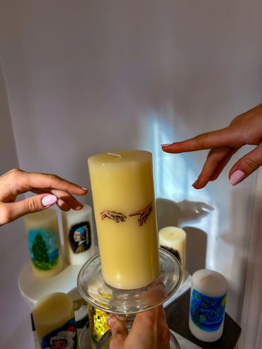 Two hands almost touching over a candle with hand illustrations.