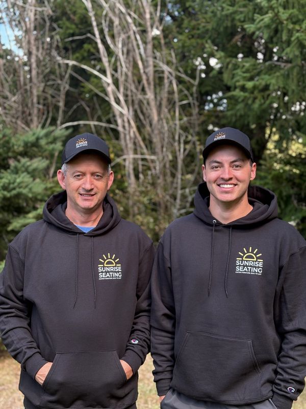 Two men in matching Sunrise Seating hoodies and caps outdoors.