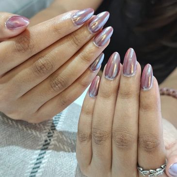 Hands with shiny metallic pink nail polish and almond-shaped nails.