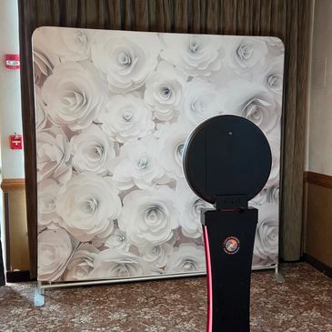 Photo booth setup with floral backdrop.
