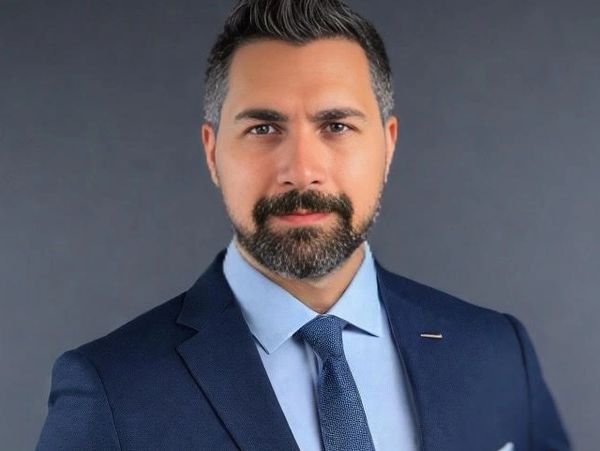 Professional man in a navy suit and tie with a confident expression.