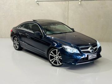 Sleek dark blue Mercedes-Benz coupe parked indoors with modern design.