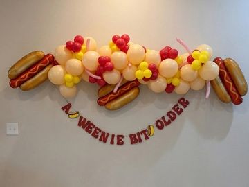 Hot dog balloon decoration with banner.