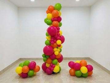 Colorful balloon column and clusters in an empty room.