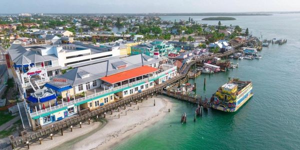 A colorful waterfront town with a dock and a ferry boat.