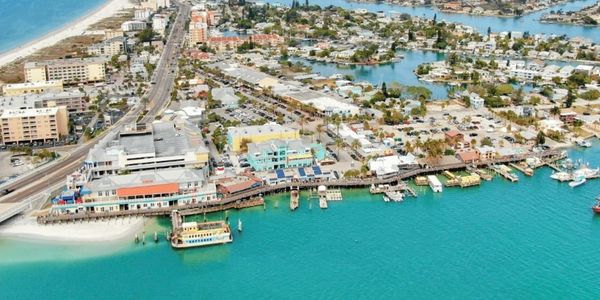 Aerial view of a coastal town with turquoise water and docks.