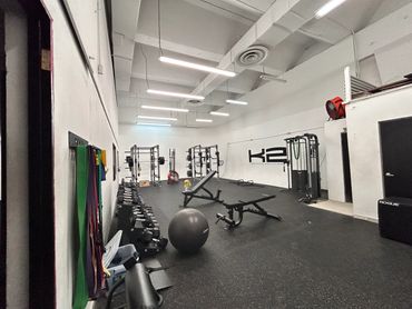 Spacious gym with weightlifting and exercise equipment.