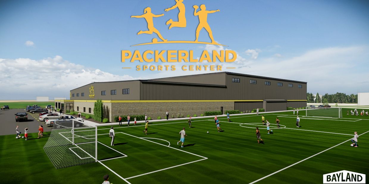 People playing soccer outside Packerland Sports Center on artificial turf.