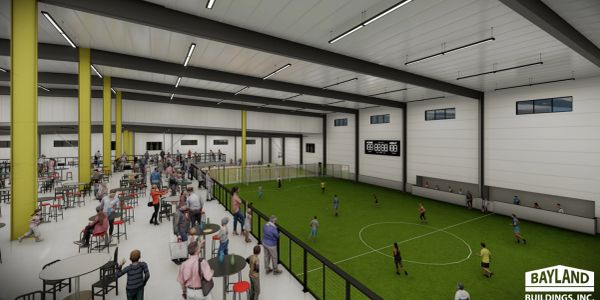 Indoor soccer facility with spectators and players.