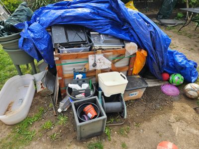 Pile of miscellaneous outdoor items covered with a blue tarp.
