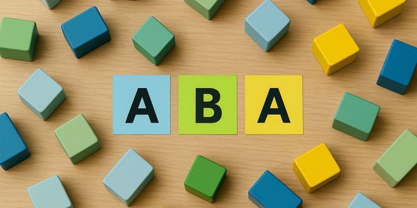 Colorful blocks surround cards spelling 'ABA' on a wooden surface.