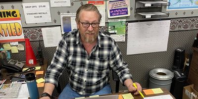 Businessman sitting at his desk smiling while talking to a customer.