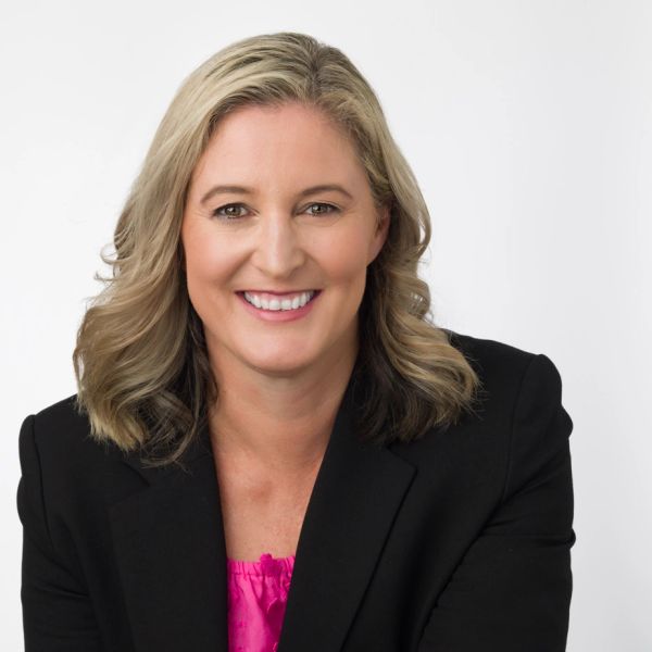 Professional woman smiling with blonde hair and black blazer.
