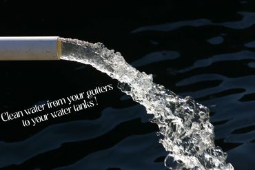 Clear water flowing from a pipe into a dark body of water.