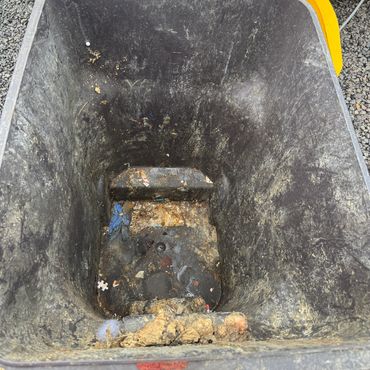Interior of a dirty, empty garbage bin with some debris and grime.