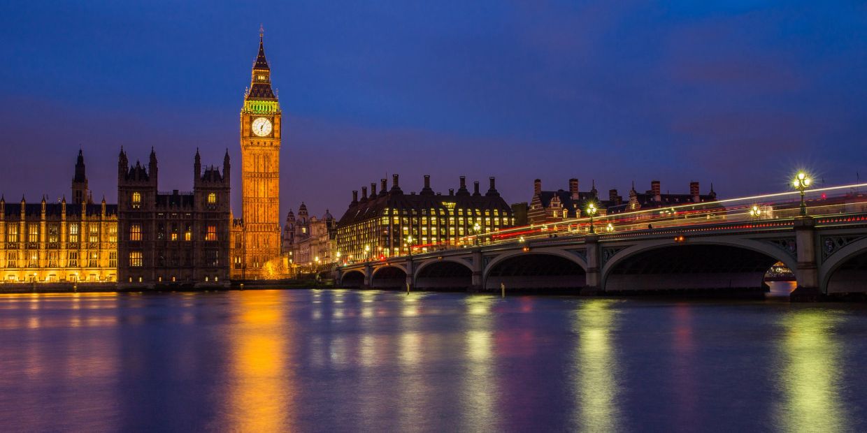 Big Ben and Westminster Bridge at night with reflections on the Thames.