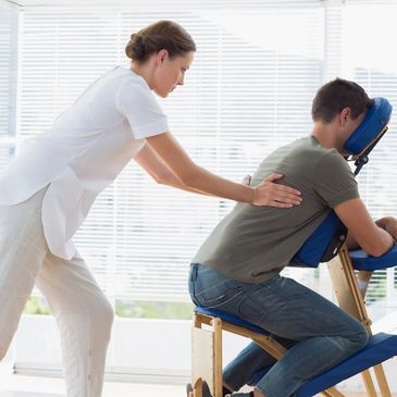 Therapist massaging man's upper back.