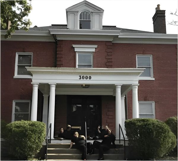 A brick building with white columns features the number 3000 on the front.