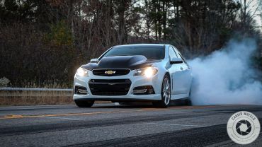 White Chevrolet car doing a burnout with smoke.