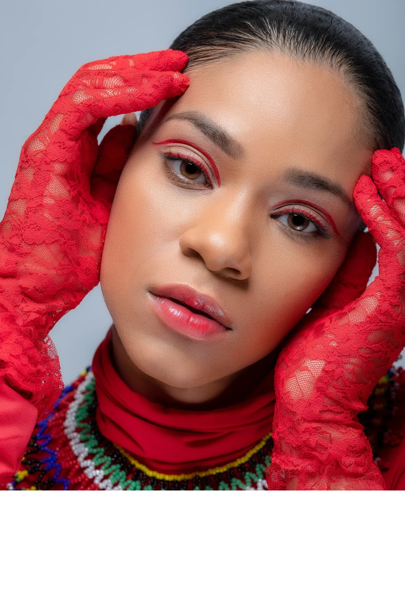 Model wearing red lace gloves and red turtleneck with soft pink red lip gloss and red graphic liner