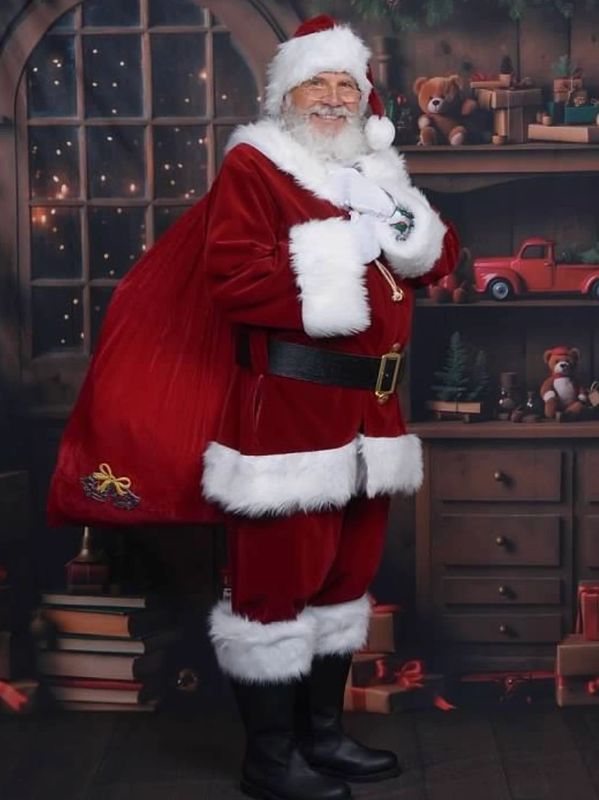 Santa Claus stands happily with a sack of presents in a cozy, festive room.
