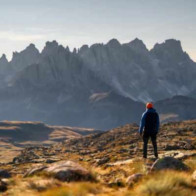 Person in a blue jacket hiking in mountainous terrain.