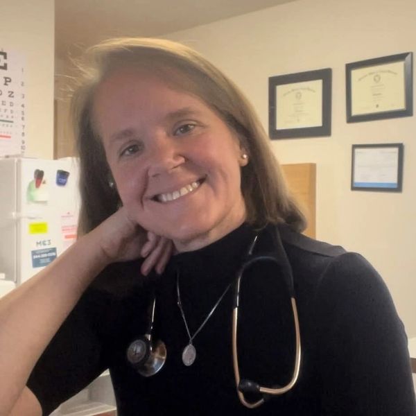 Female doctor smiling with stethoscope.