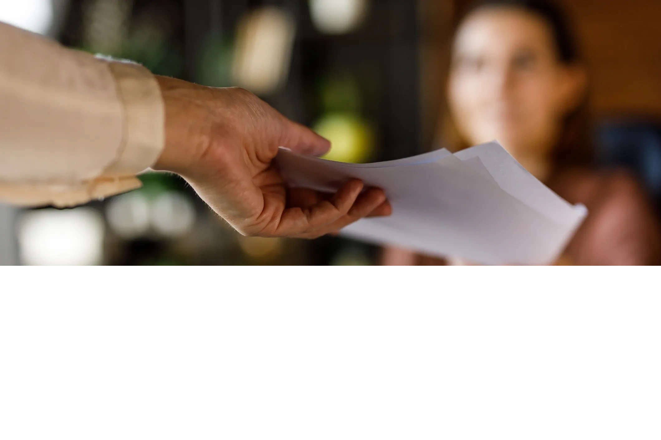Person handing over documents to another individual.