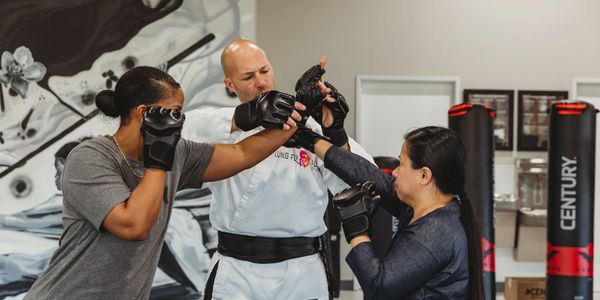 Women practicing martial arts self-defense techniques at Kung Fu Academy, building confidence and sa